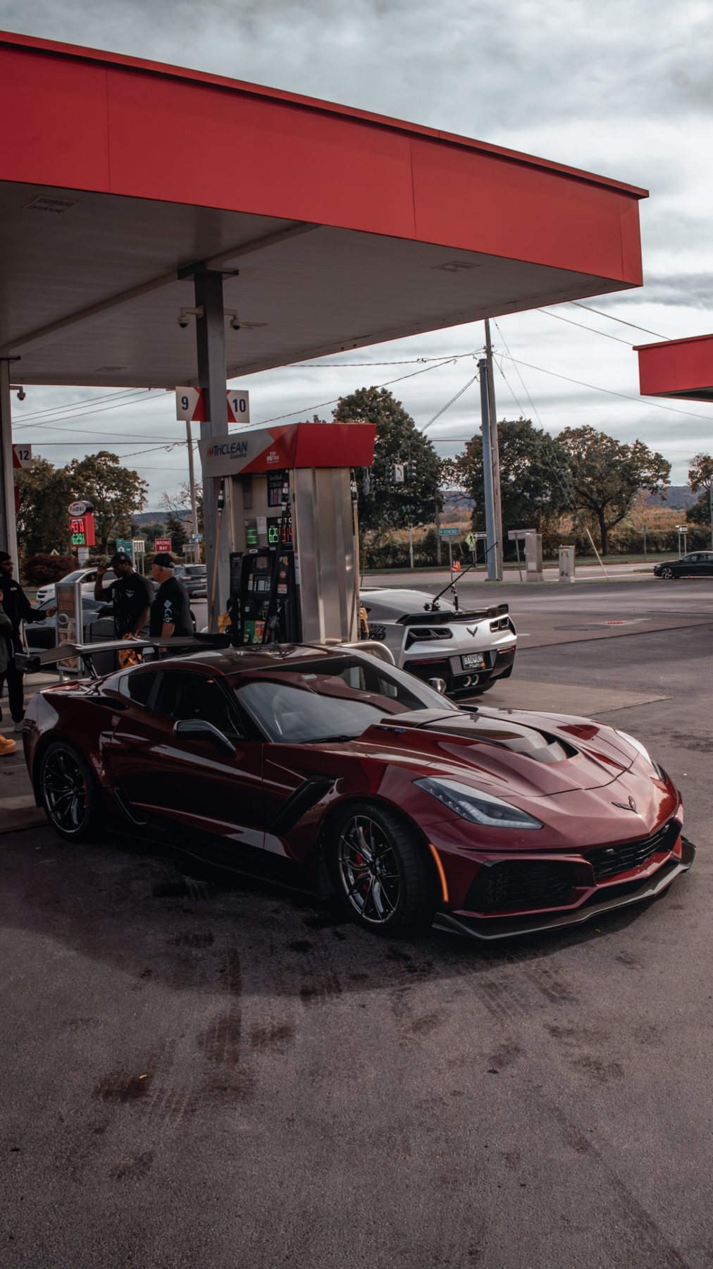 Dark red Corvette at a gas station (portrait)